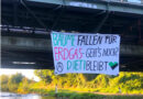 Für den Erhalt des Dietenbachwaldes: Aktivist:innen hängen Banner an Eisenbahnbrücke auf